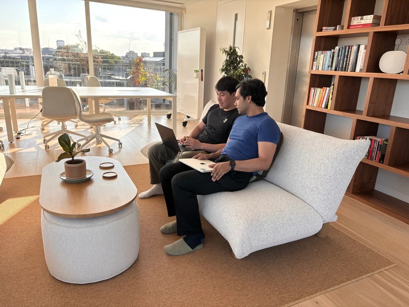 Two Anima colleagues working together on the sofa
